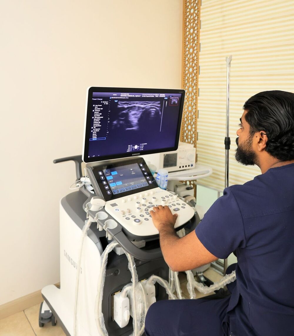 Consultant performing a high-resolution thyroid ultrasound on the clinic's Samsung scanner in Nairobi